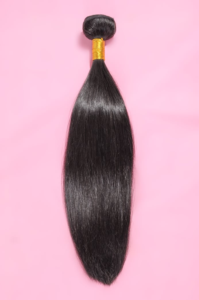 straight black human hair weaves extensions bundle on pink background